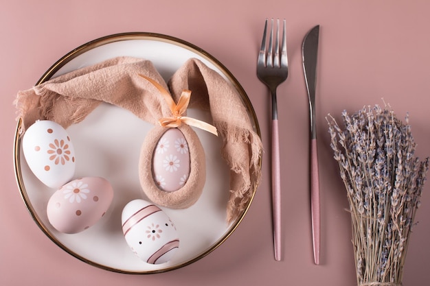 Easter table setting Painted Easter eggs on a white plate top view