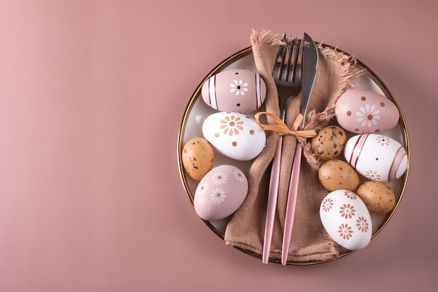 Easter table setting Painted Easter eggs on a white plate top view