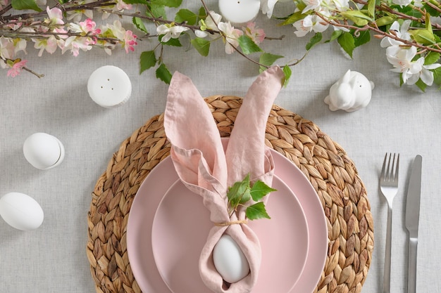 Easter table setting with yellow chickdecorations fresh flowers and eggs Elegance dinner at home Close up