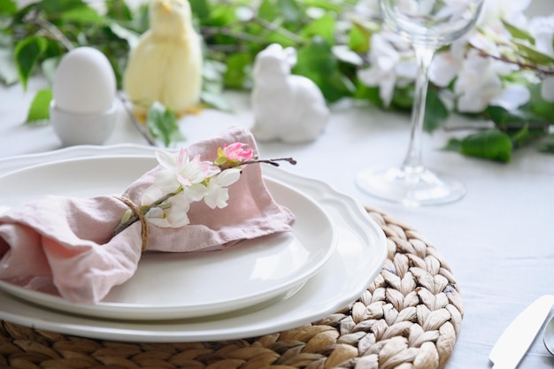 Easter table setting with yellow chickdecorations fresh flowers and eggs Elegance dinner at home