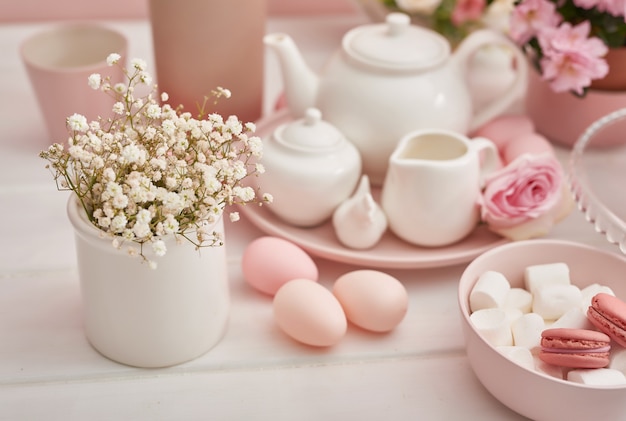 Easter tea-set and colorful eggs on festive table.