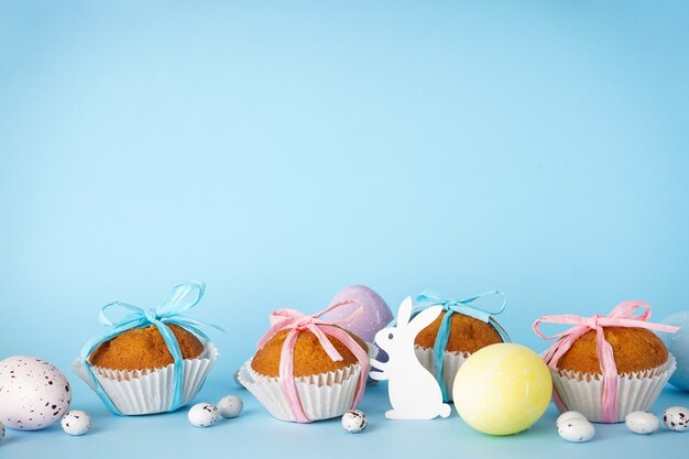 Easter treats, colorful cupcakes on a blue background, place for text.