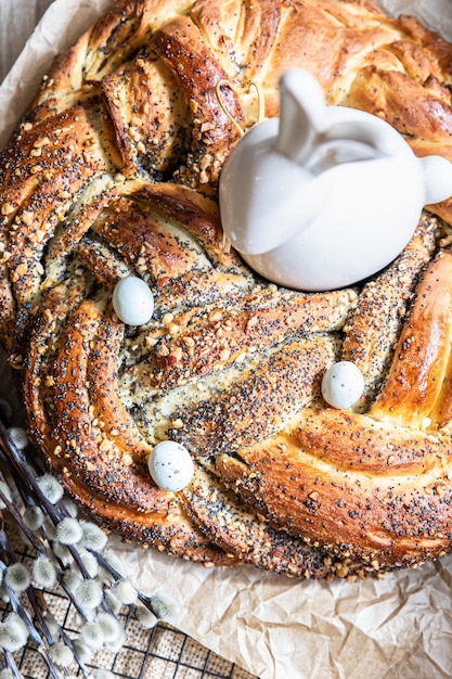 Easter twist bread with poppy seed and nut filling decorated with willow twigs and Easter eggs