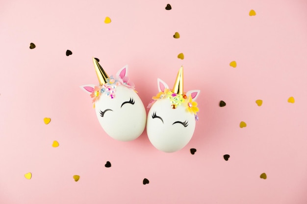 Easter unicorn eggs isolated on pink background with heart shape golden confetti happy easter banner