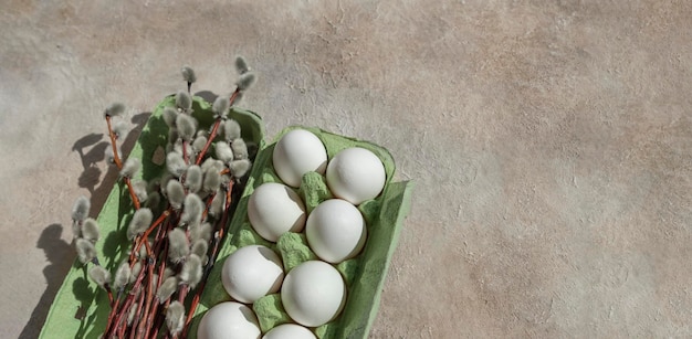 Easter. White eggs in a recycled cardboard box with willow bouquet. Copy space.