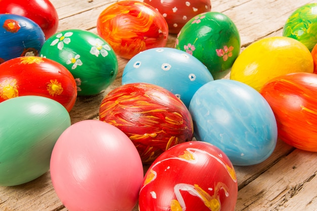 Easter with handmade colored eggs on wooden table.