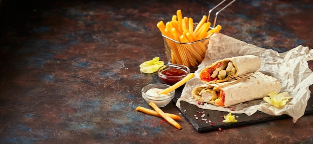 Eastern traditional shawarma with chicken and vegetables and French fries with sauces