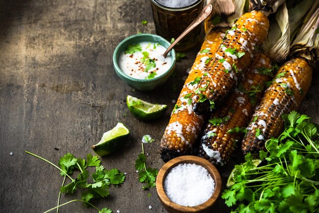 Eating grilled corn cobs with fresh herbslimebeer and salsa