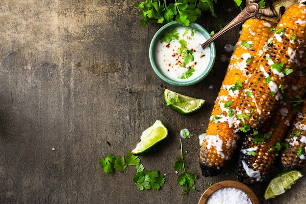 Eating grilled corn cobs with fresh herbslimebeer and salsa