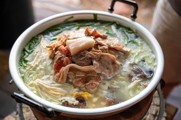 Eating grilled pork with vegetable and soup in hot pan. Thai traditional barbecue.