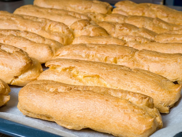 Eclairs after oven lying on baking paper on a baking sheet