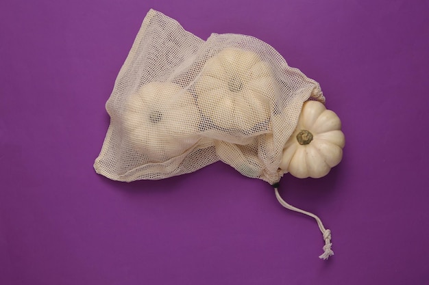 Eco bag with mini pumpkins on purple background