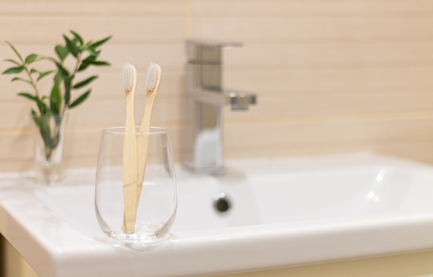 Eco bamboo toothbrushes in a glass in bathroom