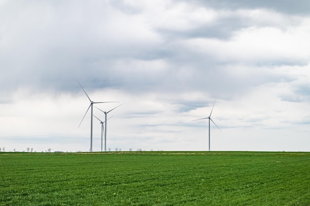 Eco banner or header image of three wind turbines of a wind farm producing renewable energy Clean green alternative power Wind energy to fight climate change and global warming