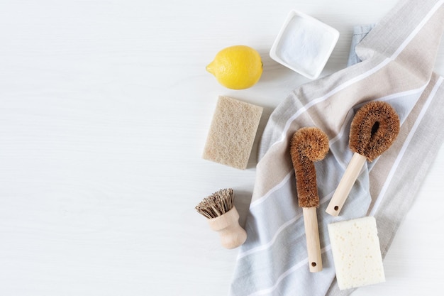 Eco friendly bamboo dish brushes and lemon with baking soda for cleaning top view