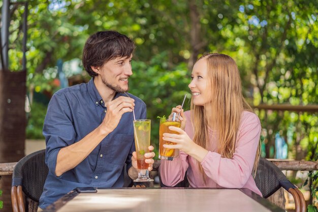 Eco friendly couple using reusable stainless steel straw to drink fruit tea