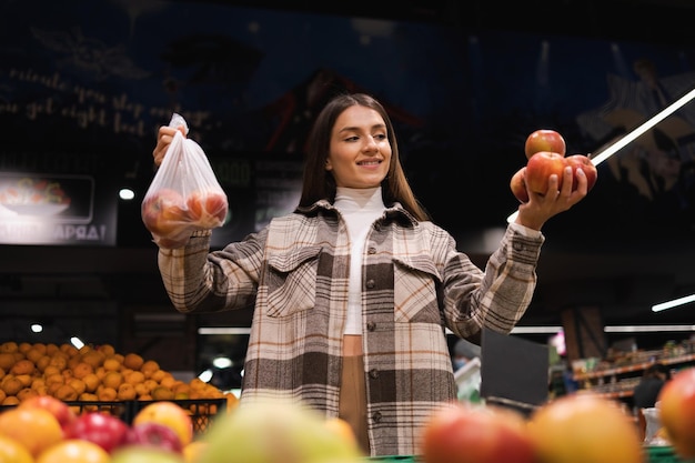 Eco friendly woman buys apples in the supermarket