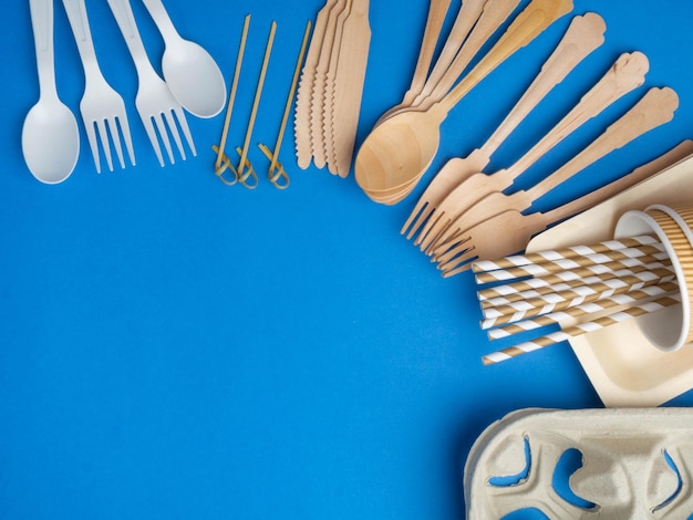 Ecofriendly biodegradable cutlery Ecological disposable tableware for food on a trendy blue color background