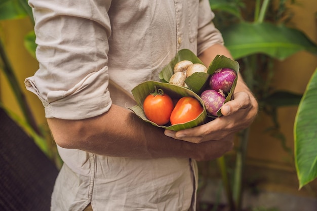 Ecofriendly product packaging concept Vegetables wrapped in a banana leaf as an alternative to a plastic bag Zero waste concept Alternative packaging