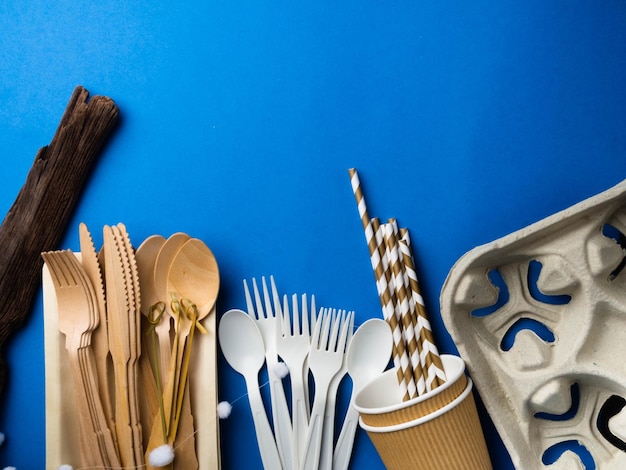 Ecological biodegradable and plastic disposable tableware for food on a blue background