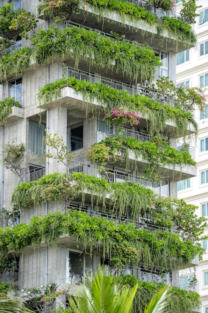 Ecological buildings facade with green plants and flowers on stone wall of the facade of the house on the street of Danang Vietnam