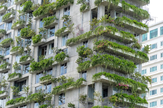 Ecological buildings facade with green plants and flowers on stone wall of the facade of the house on the street of Danang Vietnam