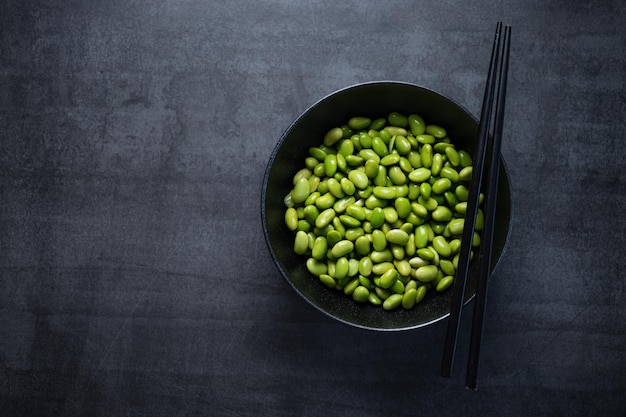 Edamame beans in bowl on dark