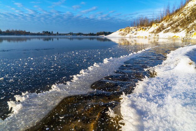 The edge of the ice on the pond in the early frosty morning