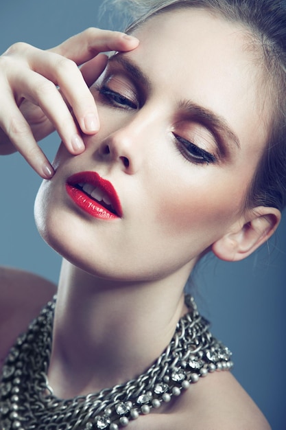 Edgy elegance Closeup shot of a gorgeous young woman wearing bright red lipstick and an elegant necklace