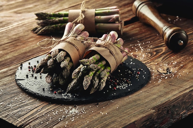 An edible raw stems of asparagus on a wooden background