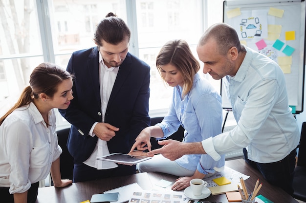 Editors using digital tablet in meeting room