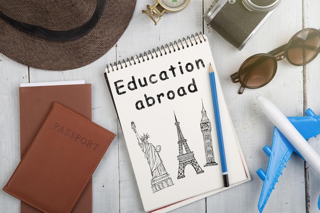 Education abroad concept sketch of Eiffel tower Airline tickets passport sunglasses and camera on wooden desk