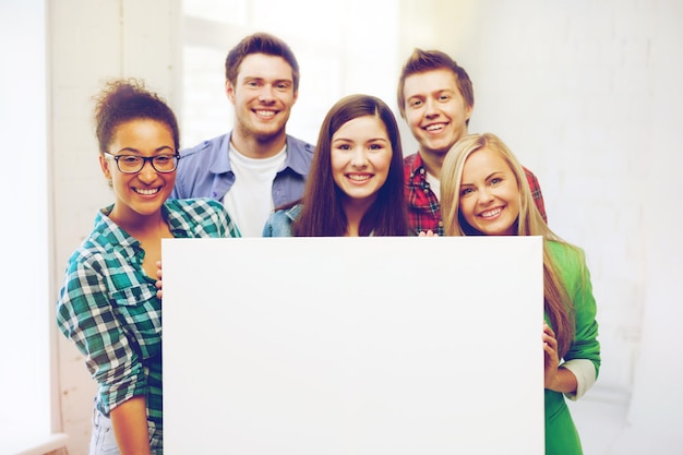 education concept - group of students at school with blank white board