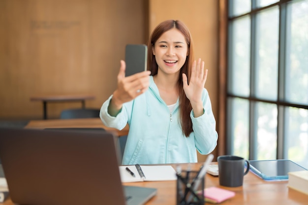 Education concept Teenage girl using smartphone to video call with friends after study tutorial