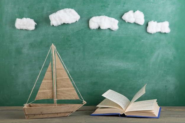 Education is a journey concept toy boat and books on the chalkboard background inspiration for a fairy tale