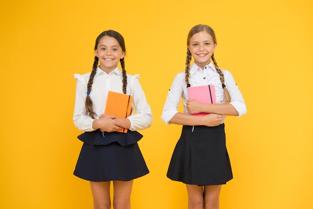 Education is step by step process of getting knowledge. Classmates having fun at school. Happy childhood. School education concept. Friends adorable pupils. Schoolgirls formal style school uniform.