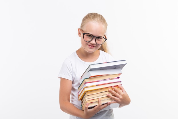 Education, people, children and school concept - School student in goggles holding books in hands on white background