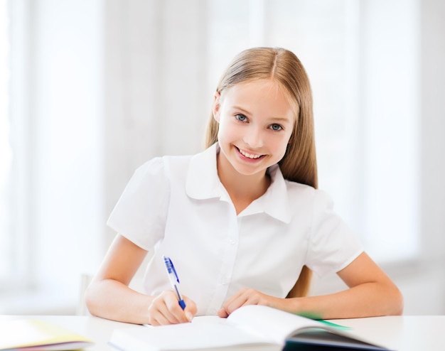 education and school concept - little student girl studying at school