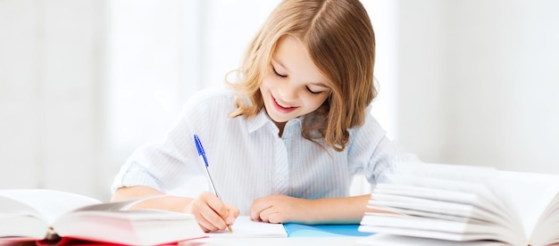 education and school concept - little student girl studying at school