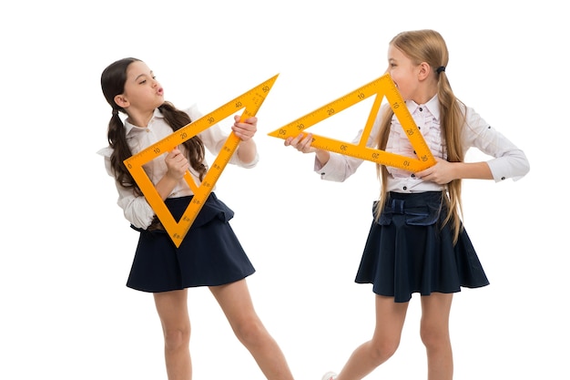 Education and school concept. School students learning geometry. Kids school uniform isolated white. STEM concept. Learn theorem about right angle. Girls with big rulers. Favorite school subject.