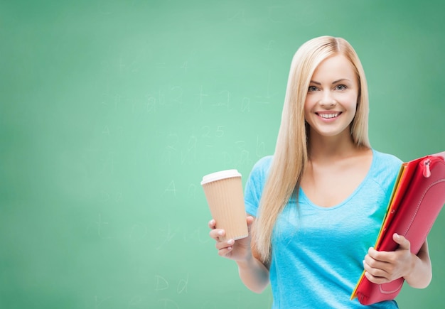 education, school, drinks and people concept - smiling student girl with folders and cup of coffee over green chalk board background