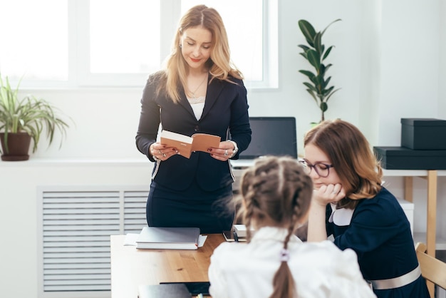 Education school lesson female teacher read book to her pupils