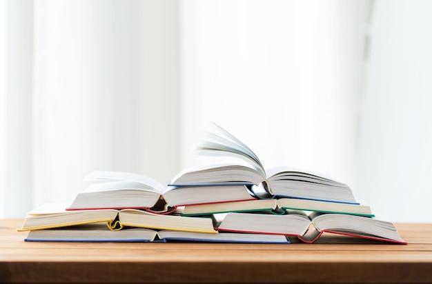 education, school, literature, reading and knowledge concept - close up of books on wooden table