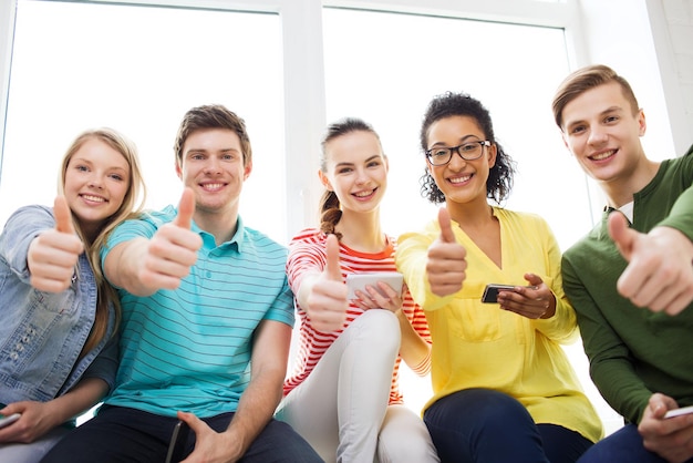 education, school and technology concept - smiling students with smartphone texting at school