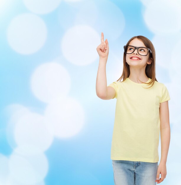 education, school and vision concept - smiling cute little girl in black eyeglasses