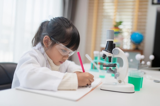 Education science chemistry and children concept kids or students with test tube making experiment at school laboratory