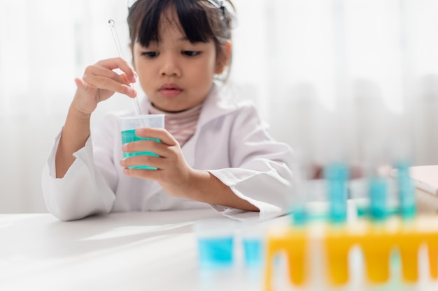 Education science chemistry and children concept kids or students with test tube making experiment at school laboratory