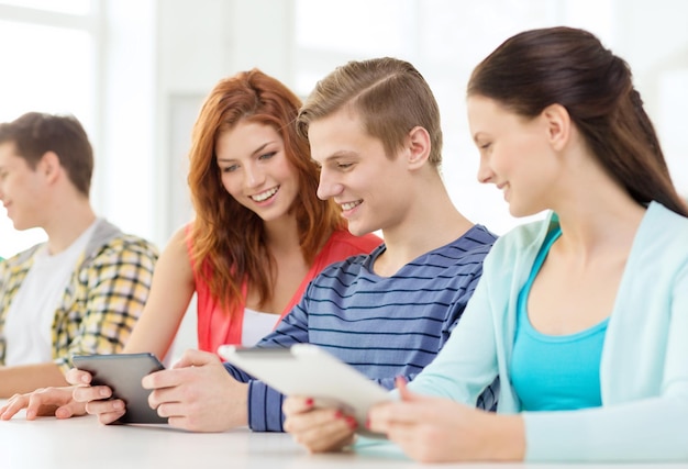 education, technology and internet concept - smiling students with tablet pc computers at school