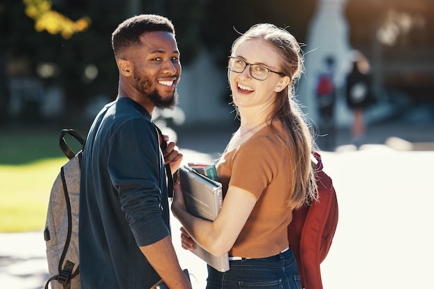 Education university and students with couple who are interracial on campus for academic and learning Black man woman and smile in portrait with books to study outdoor and college life