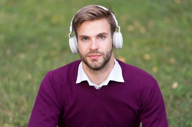 Education with ebook man with bristle in headset listening music while relax in park